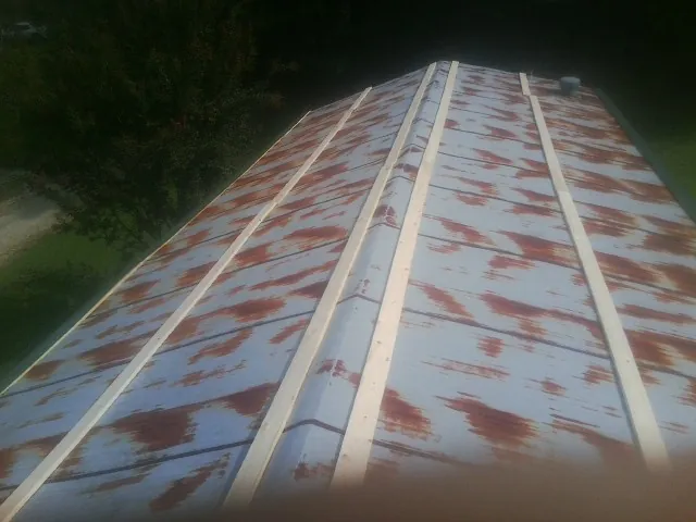 Rusted metal roof panels with new wood purlins before replacement — Storm Damage Roof Repair in Emden by Roofing Brothers