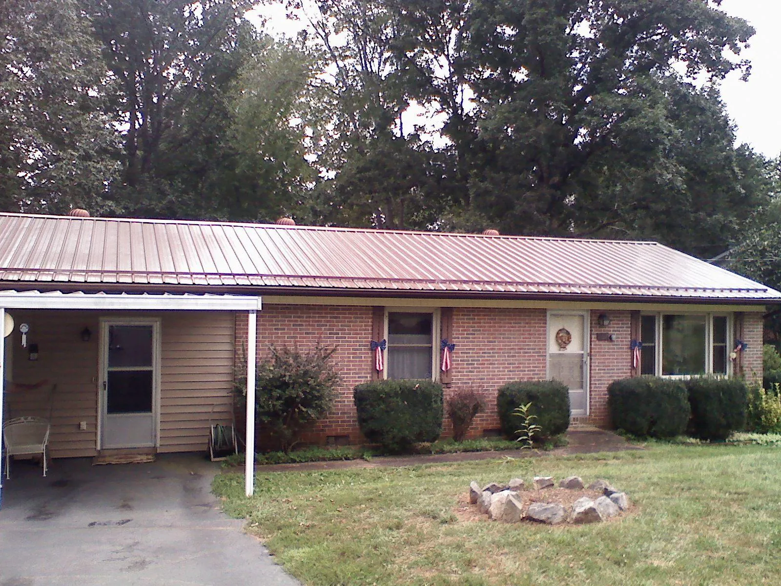 Bronze metal roof and carport on a brick ranch home — Roof Repair work by our crew in Emden